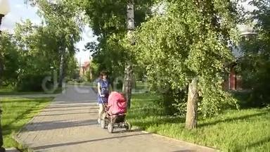美丽的年轻妈妈带着婴儿车在公园散步，暑<strong>假放假</strong>一天